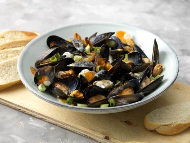 Creamy pan of mussels with carrot, lemon and spring onion